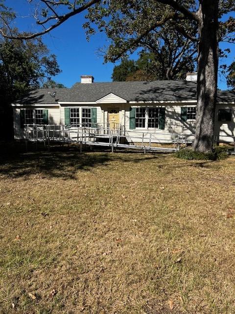 rear view of house featuring a yard