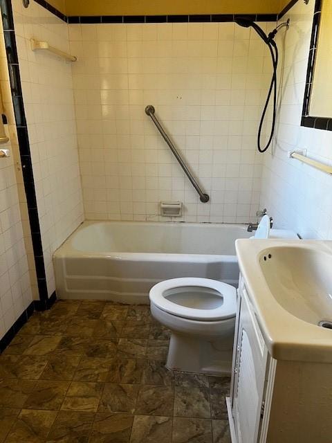 bathroom featuring toilet, vanity, and shower / bathing tub combination