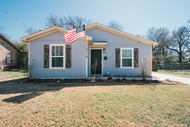 view of front of house with fence and a front lawn