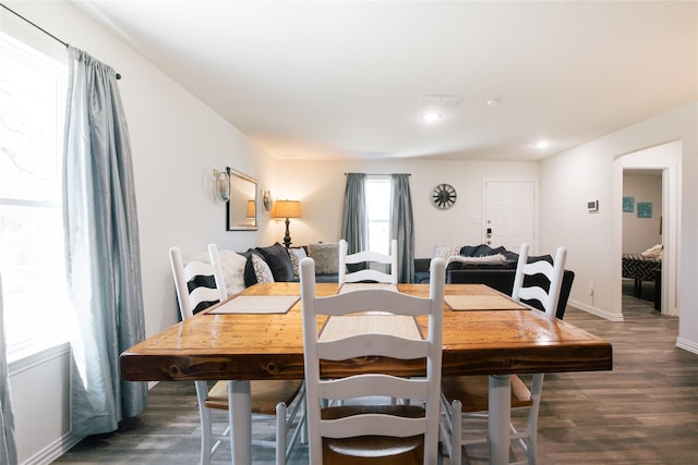 dining space with baseboards, wood finished floors, and recessed lighting