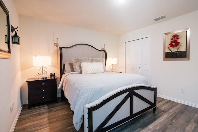 bedroom with baseboards, a closet, visible vents, and dark wood-type flooring