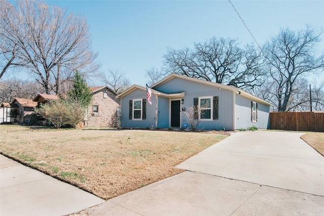 view of front of home featuring fence, concrete driveway, and a front yard