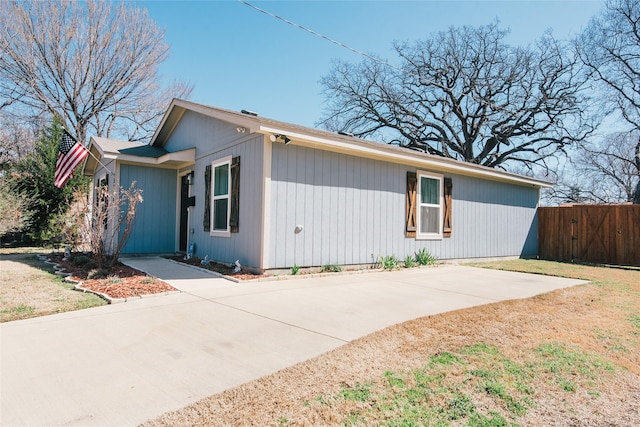 view of home's exterior featuring driveway and fence