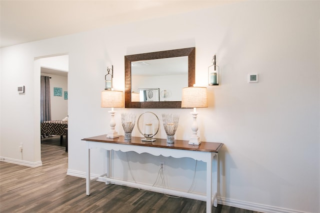 hall featuring baseboards and wood finished floors