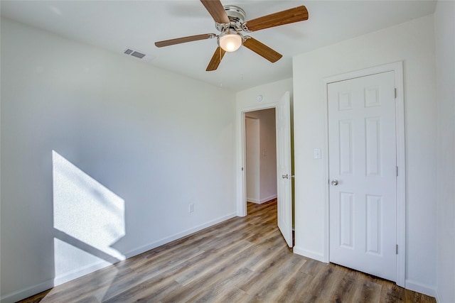 unfurnished bedroom featuring visible vents, ceiling fan, baseboards, and wood finished floors