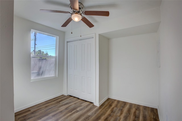 unfurnished bedroom featuring a ceiling fan, a closet, baseboards, and wood finished floors