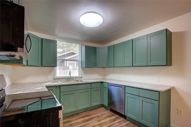 kitchen featuring green cabinets, black appliances, light wood-type flooring, and a sink