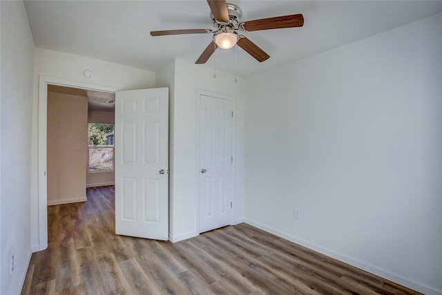 unfurnished bedroom with a ceiling fan, a closet, baseboards, and wood finished floors