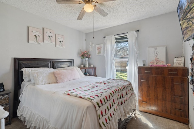 carpeted bedroom featuring a textured ceiling and ceiling fan