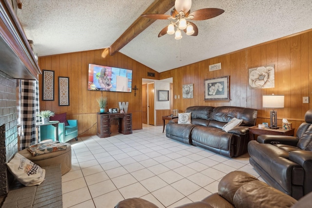 living area featuring lofted ceiling with beams, a textured ceiling, light tile patterned flooring, wood walls, and a ceiling fan