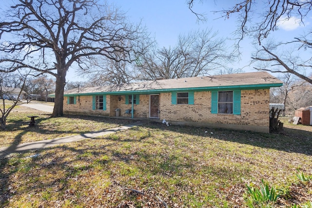 ranch-style house with a front yard and brick siding