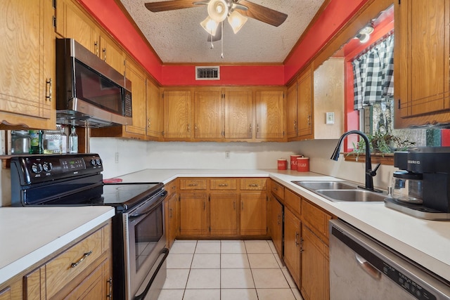 kitchen featuring appliances with stainless steel finishes, brown cabinetry, visible vents, and a sink