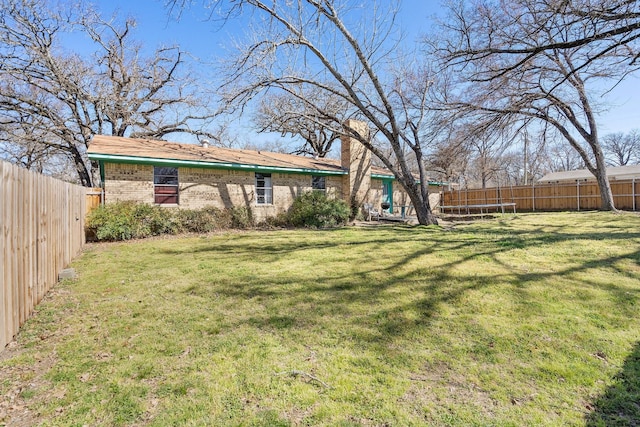 view of yard featuring a trampoline and a fenced backyard