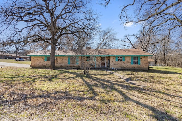 ranch-style house with a front yard and brick siding