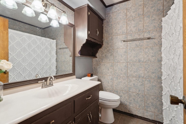 bathroom with toilet, tile patterned floors, curtained shower, vanity, and tile walls