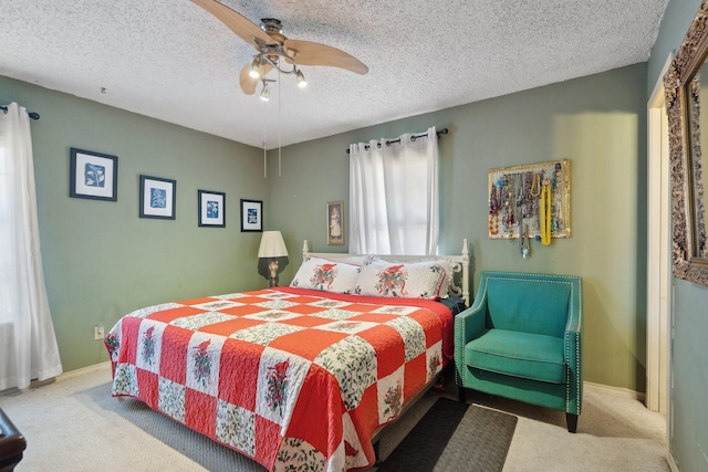 carpeted bedroom featuring a ceiling fan, baseboards, and a textured ceiling