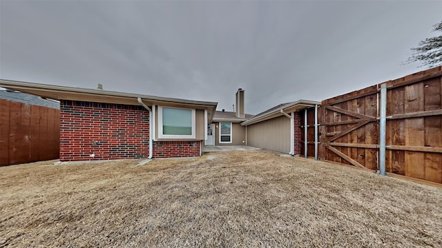 view of front of property featuring brick siding and fence