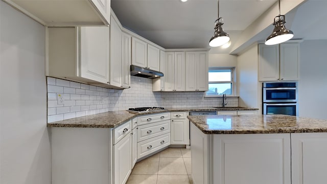 kitchen featuring under cabinet range hood, stainless steel appliances, a sink, white cabinetry, and tasteful backsplash