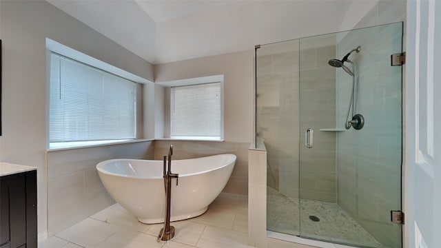 full bath with a freestanding bath, a shower stall, tile walls, and tile patterned floors