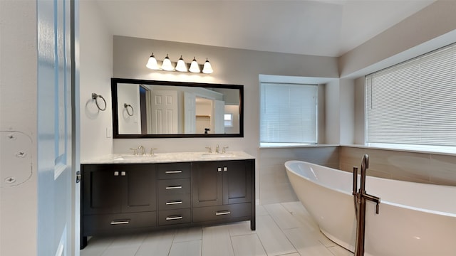 full bath featuring a freestanding bath, double vanity, and a sink