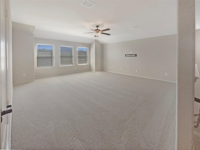 carpeted spare room with baseboards, visible vents, and a ceiling fan