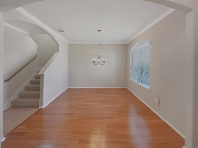 unfurnished dining area with visible vents, ornamental molding, light wood-style flooring, and a notable chandelier