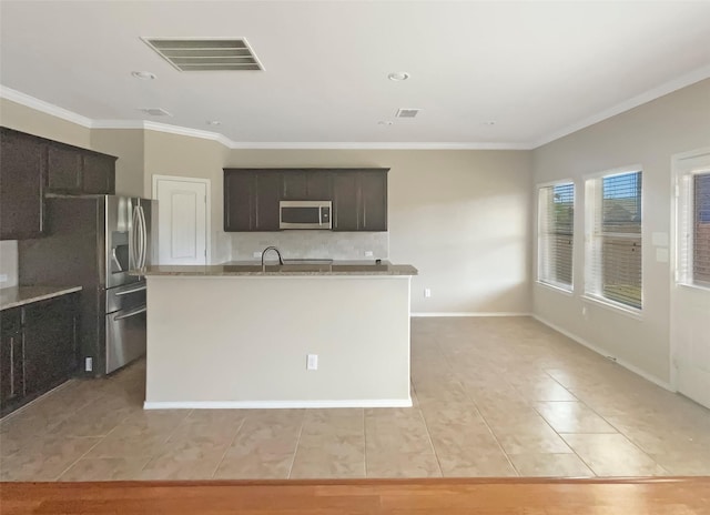 kitchen featuring dark brown cabinetry, visible vents, ornamental molding, a kitchen island with sink, and stainless steel appliances