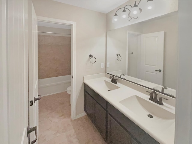 full bathroom featuring double vanity, a sink, and toilet