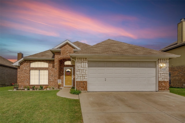 ranch-style home with driveway, roof with shingles, an attached garage, a front lawn, and brick siding