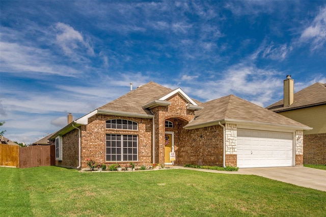 view of front of property featuring brick siding, fence, a front yard, driveway, and an attached garage