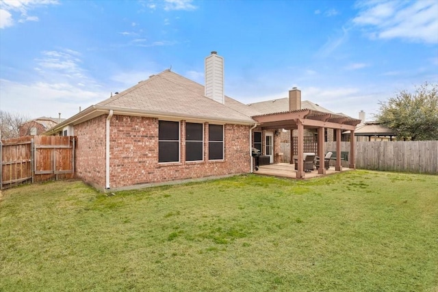 back of property with a pergola, a fenced backyard, a yard, brick siding, and a patio area