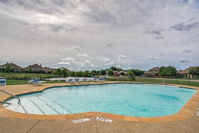 community pool with a patio and fence