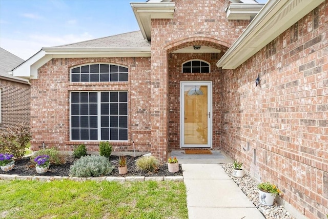 property entrance with brick siding and roof with shingles