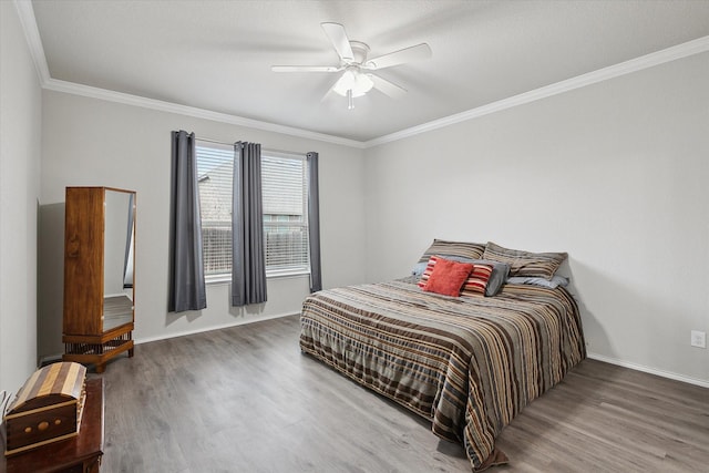 bedroom featuring crown molding, baseboards, and wood finished floors