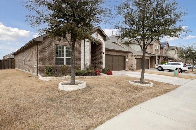 view of front of house with a garage, brick siding, fence, driveway, and a front lawn