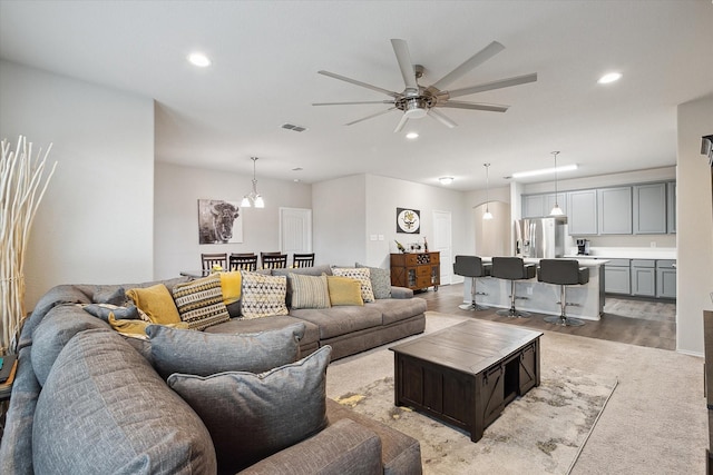 living area featuring light wood-style floors, recessed lighting, visible vents, and ceiling fan