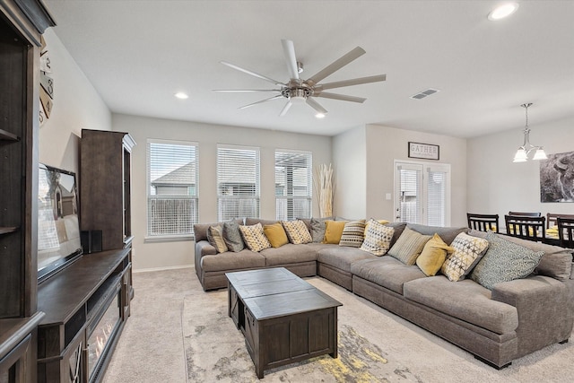 living area with recessed lighting, light colored carpet, visible vents, baseboards, and ceiling fan with notable chandelier