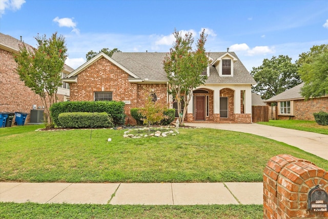 view of front of home featuring brick siding, roof with shingles, central AC unit, driveway, and a front lawn