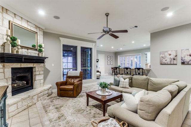 tiled living room featuring ornamental molding, a fireplace, and visible vents