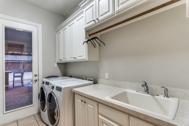 laundry area featuring washer and dryer, cabinet space, a sink, and light tile patterned flooring