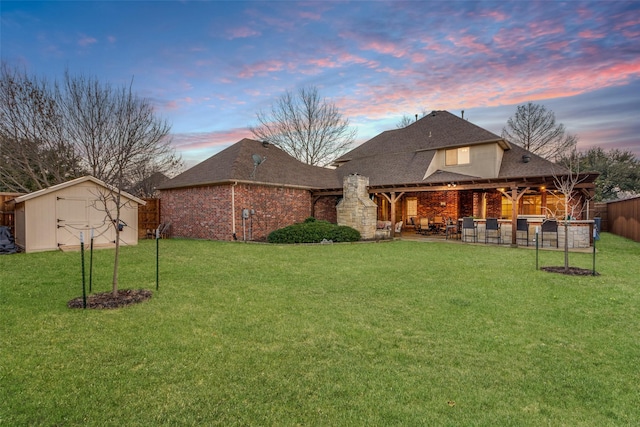 view of yard with a patio area, a storage shed, fence, and an outdoor structure