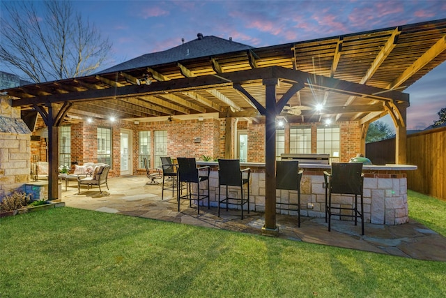 view of patio featuring outdoor dry bar, outdoor lounge area, fence, and a pergola