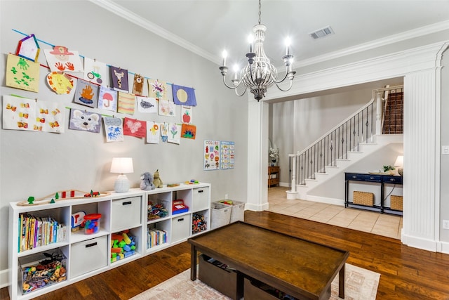 game room with an inviting chandelier, crown molding, visible vents, and wood finished floors