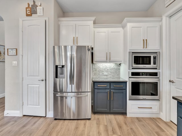 kitchen with stainless steel appliances, decorative backsplash, light wood-style flooring, and white cabinets