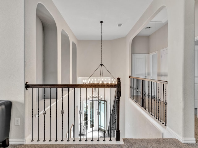 corridor with visible vents and a notable chandelier