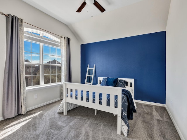 carpeted bedroom with vaulted ceiling, baseboards, and ceiling fan