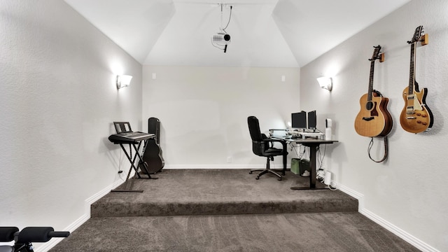 carpeted office space with baseboards and vaulted ceiling