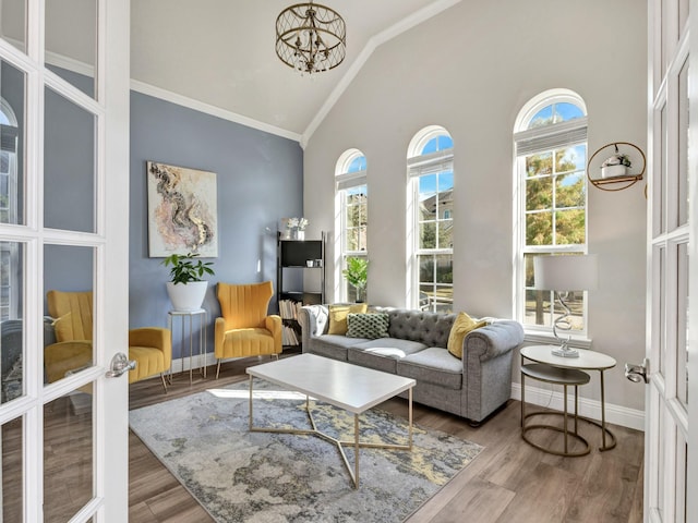 living area with baseboards, wood finished floors, and a healthy amount of sunlight