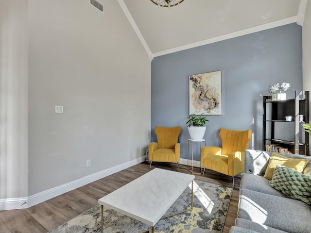 living room with ornamental molding, visible vents, baseboards, and wood finished floors