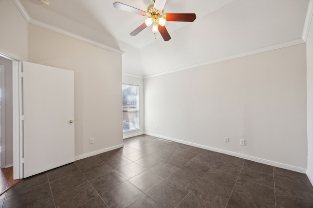 empty room with baseboards, a ceiling fan, ornamental molding, vaulted ceiling, and dark tile patterned floors